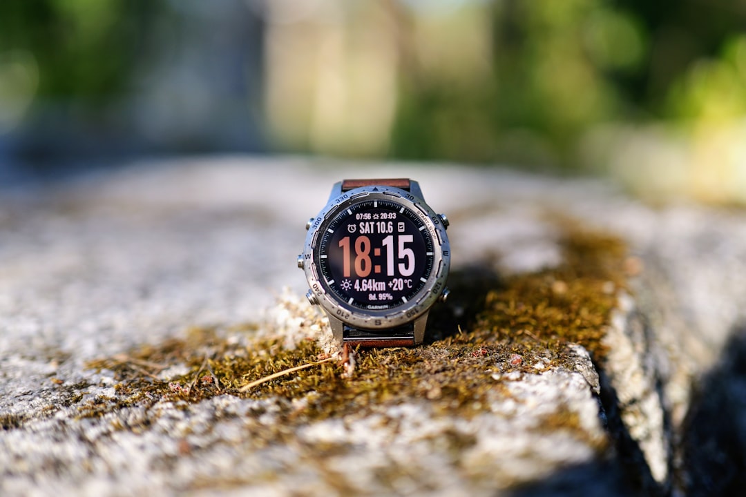 A smartwatch displays the time on a mossy surface.